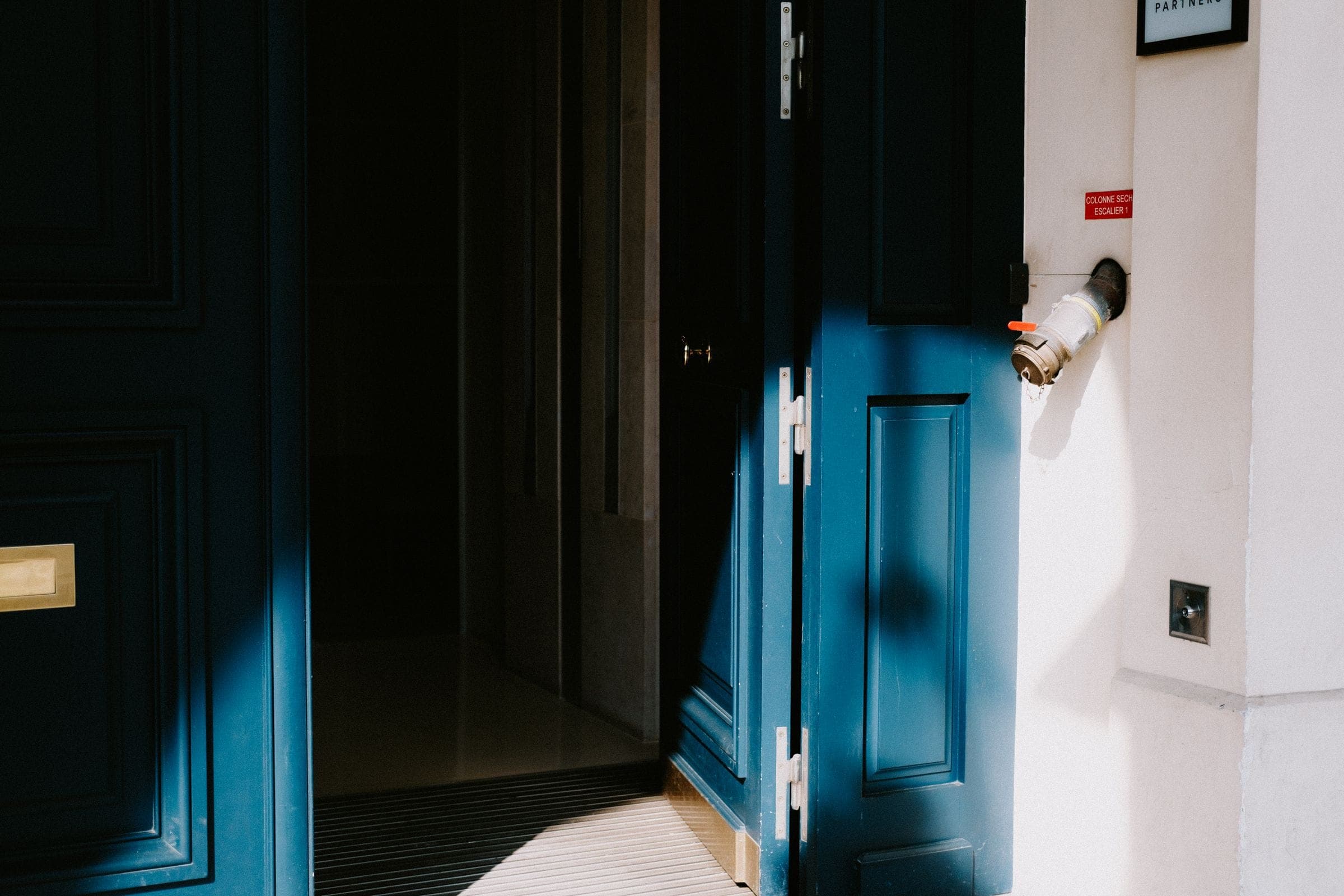 A dark painted doorway with light falling across the threshold
