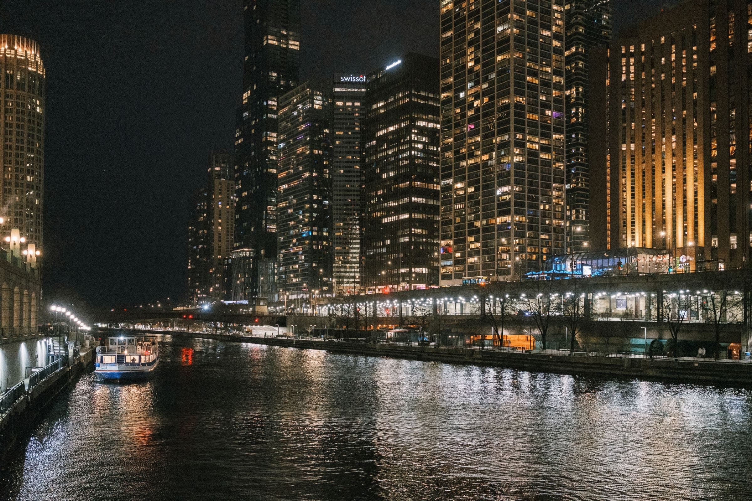 The Chicago River at night between lit towers