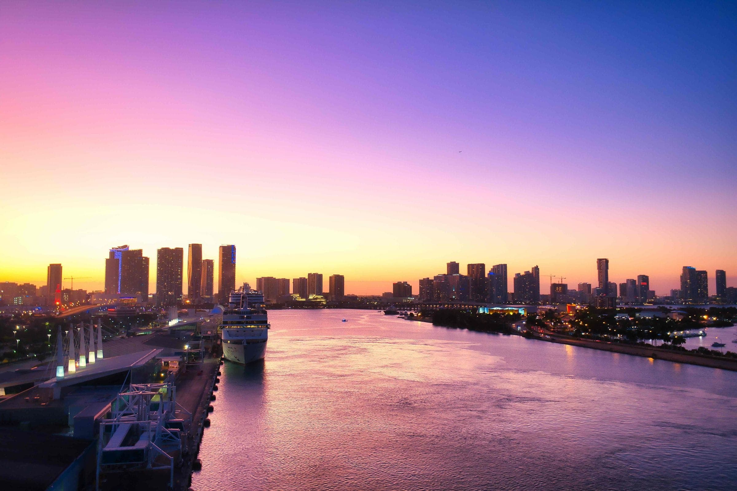 The Miami waterfront and downtown towers under a violet sunset