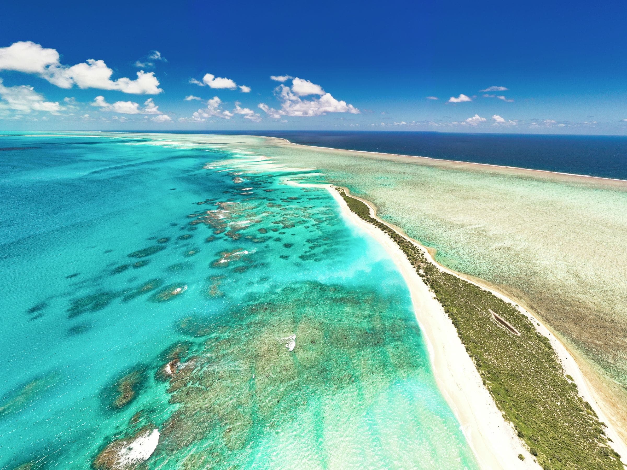 Reef, sandbar and turquoise shallows running out to open ocean