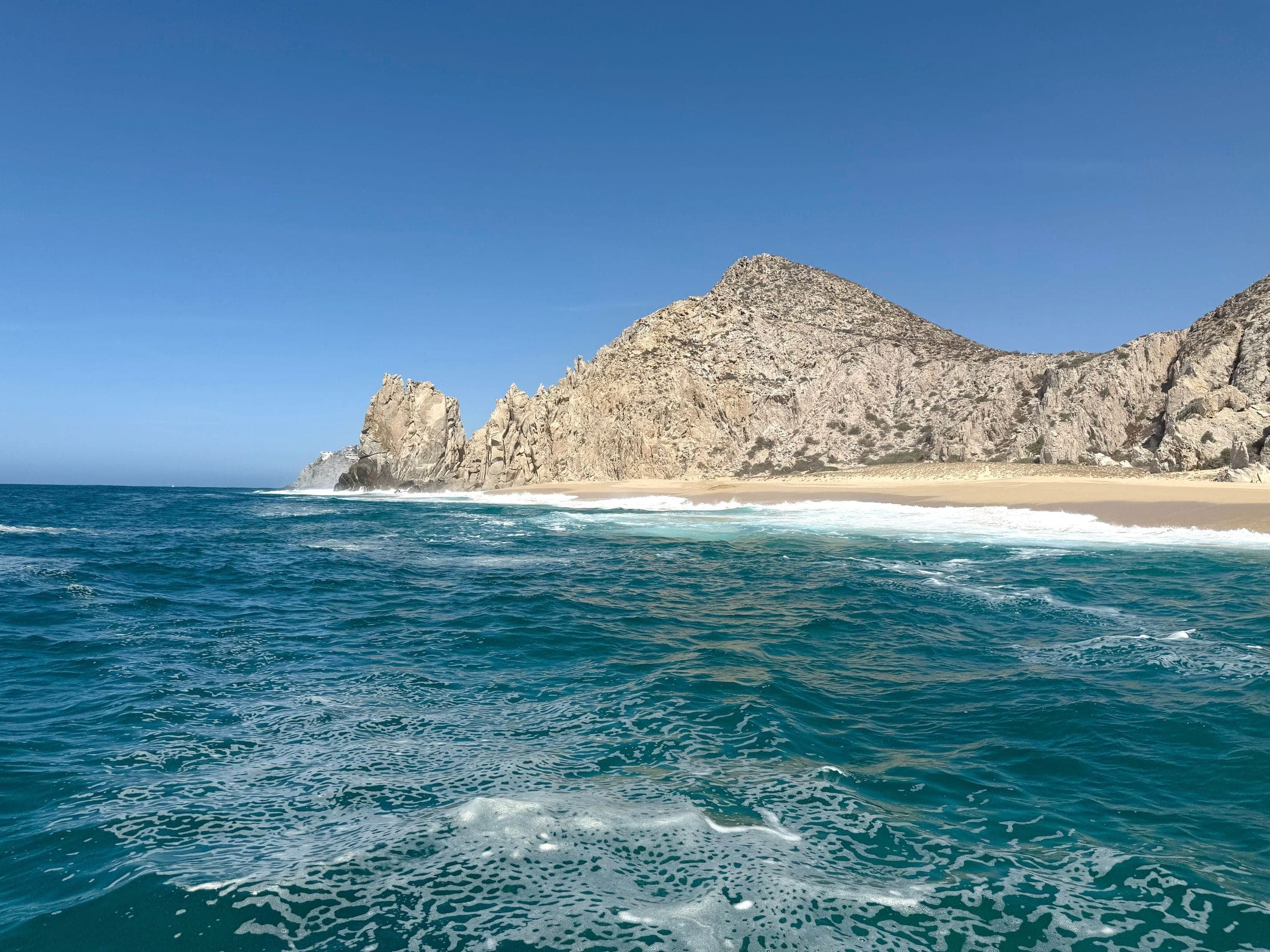 A beach below desert headlands where the Pacific meets the rock