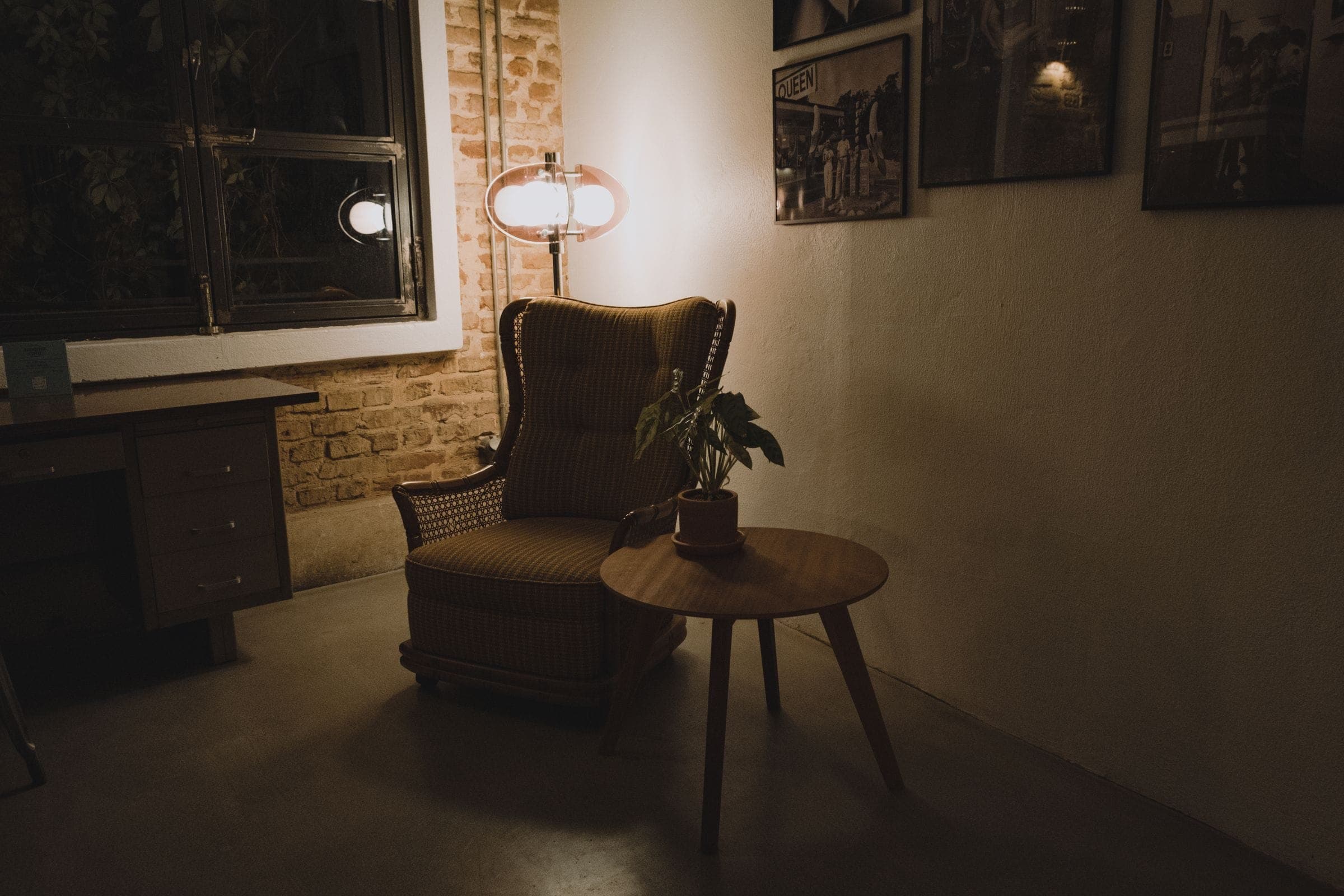 A low-lit private sitting room with a single lamp and an armchair